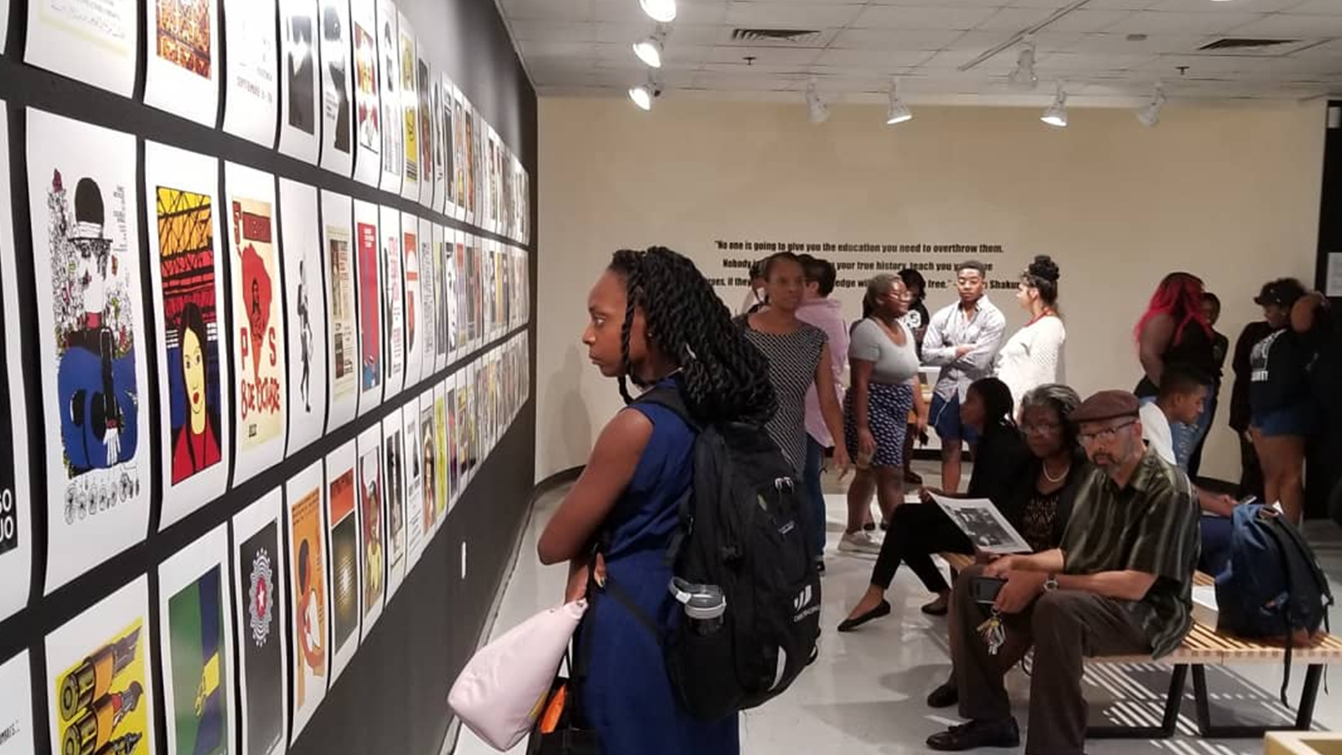 Stuident in Foster Tanner looking at art in gallery exhibit