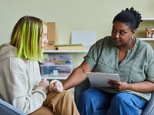 Female social worker supporting sad teenage girl during her difficult situation