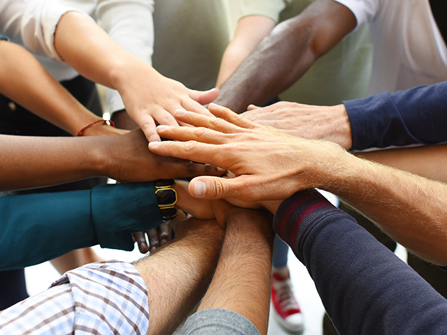 Business people with hands stacked together