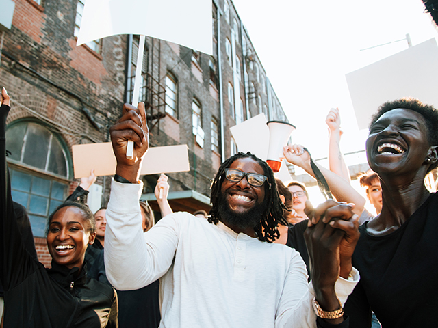 Happy activist smiling holding signs outsdie