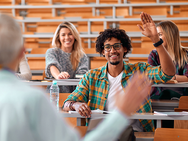 African American Male student raising hand to answer professors question during lecture