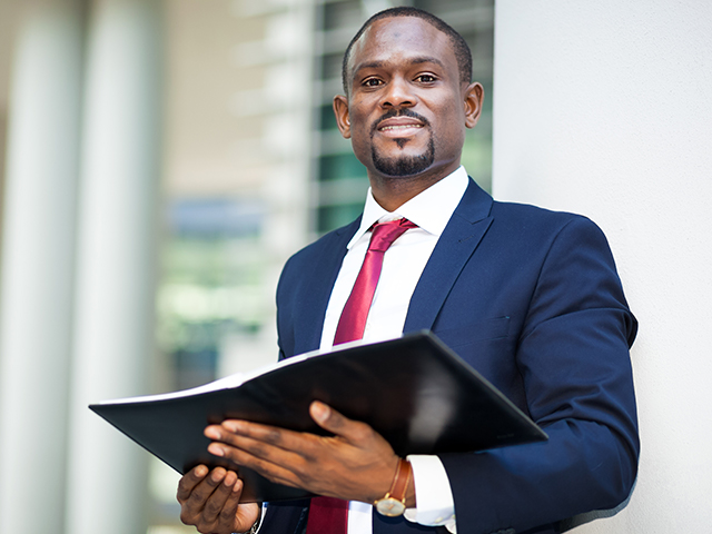 Man in business suit outdoor holding open folder 