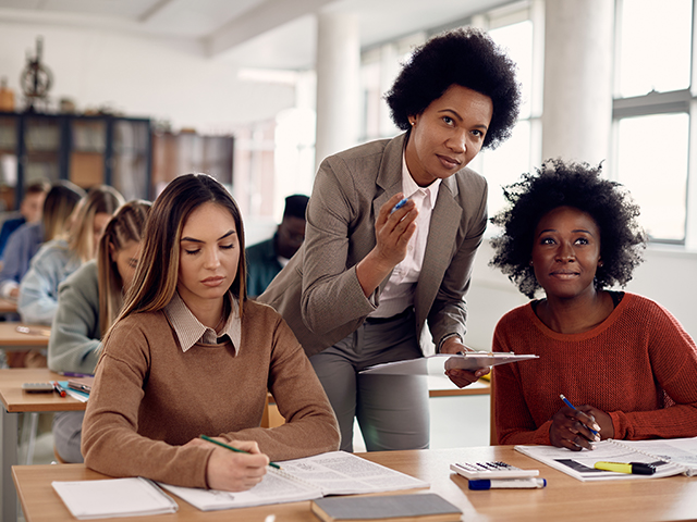 Black female professor talking to students during lecture in the classroom.