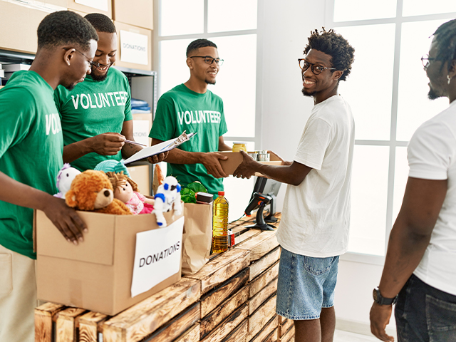 Group of young african american volunteers helping people at volunteer center.