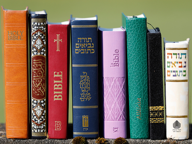 A collection of religious texts and bibles neatly arranged on a table, showcasing the diversity of spiritual literature